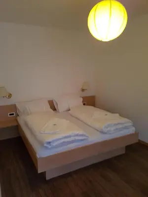 a bedroom with a bed with a light above it at Das Sonnenheim in Marlengo