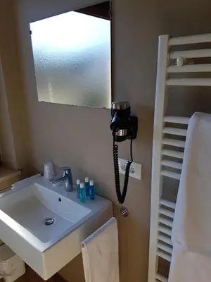 a bathroom with a sink and a phone on the wall at Das Sonnenheim in Marlengo