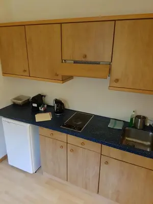 a kitchen with wooden cabinets and a black counter top at Das Sonnenheim in Marlengo