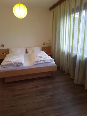 a bedroom with a white bed and a window at Das Sonnenheim in Marlengo