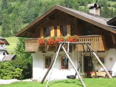 a house with a swing in front of it at Ciasa Orzun in San Vigilio Di Marebbe