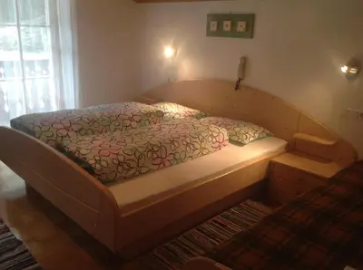 a bed in a bedroom with a wooden frame at Ciasa Orzun in San Vigilio Di Marebbe