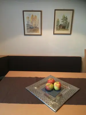 a plate of apples on a table with two pictures at Ciasa Orzun in San Vigilio Di Marebbe