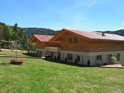 a large building with a large yard in front of it at Gasserhof Chalets in Meltina