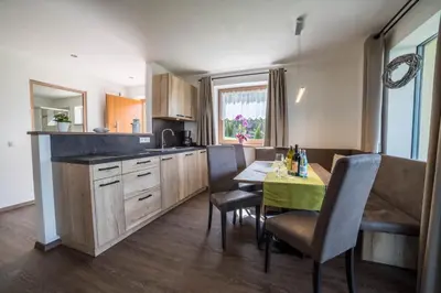 a kitchen with a table and a dining room at Gasserhof Chalets in Meltina