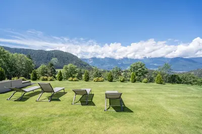 a group of chairs and tables on a grass field at Gasserhof Chalets in Meltina