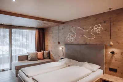 a bedroom with two beds in a room with wooden walls at B&B Aretia in Santa Cristina in Val Gardena