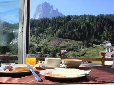 a breakfast table with a view of a mountain at B&B Aretia in Santa Cristina in Val Gardena