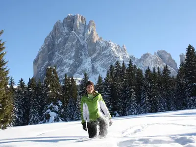 a person in the snow with a mountain in the background at B&B Aretia in Santa Cristina in Val Gardena