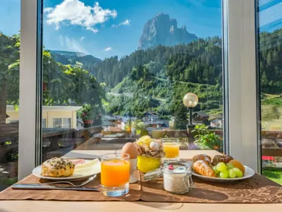 a breakfast table with a view of a mountain at B&B Aretia in Santa Cristina in Val Gardena