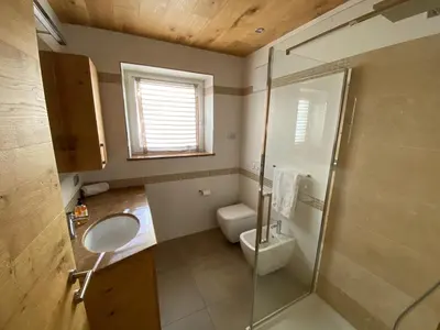 a bathroom with a toilet and a sink and a shower at Fiemme Home Mountain Apartment in Tesero