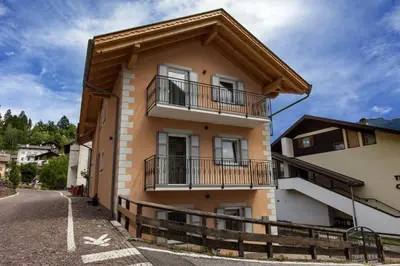 a house with balconies on the side of it at Fiemme Home Mountain Apartment in Tesero