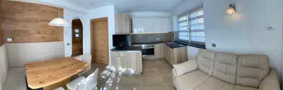 a kitchen with a couch and a table in a room at Fiemme Home Mountain Apartment in Tesero