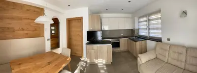 a kitchen with a couch and a table in a room at Fiemme Home Mountain Apartment in Tesero