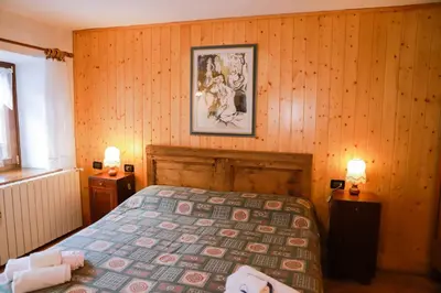 a bedroom with a bed and a picture on the wall at COL DE RIF Appartamento Storico nelle Dolomiti in Falcade