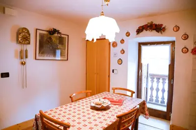 a dining room with a table and a window at COL DE RIF Appartamento Storico nelle Dolomiti in Falcade