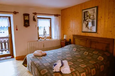 a bedroom with a bed with two stuffed animals on it at COL DE RIF Piccolo Appartamento Storico Dolomiti in Falcade