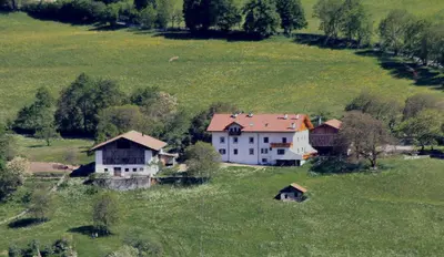a large white house in a green field at Niederhof in Parcines
