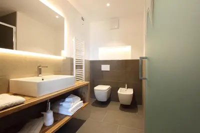 a bathroom with a sink and a toilet at DOLOMITES B&B - Suites, Apartments and SPA in Tesero
