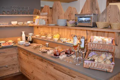 a buffet with bread and other food on a counter at DOLOMITES B&B - Suites, Apartments and SPA in Tesero
