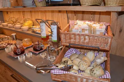 a table with baskets of food and bread on it at DOLOMITES B&B - Suites, Apartments and SPA in Tesero
