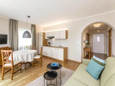 a kitchen and a living room with a table and a dining room at Apartment Pienzenau by Interhome in Postal