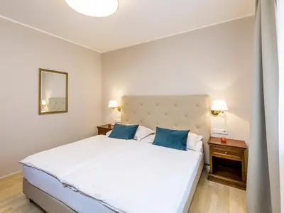 a bedroom with a large white bed with blue pillows at Apartment Pienzenau by Interhome in Postal
