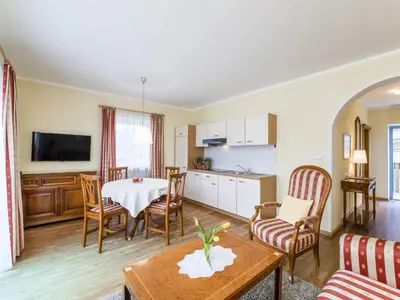 a living room with a table and a kitchen at Apartment Rametz by Interhome in Postal