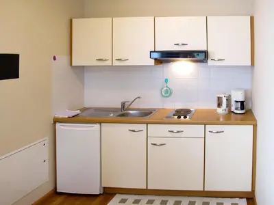 a kitchen with white cabinets and a sink at Apartment Schöneck by Interhome in Postal