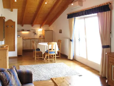 a living room with a table and a kitchen at Apartment Boymont by Interhome in Postal
