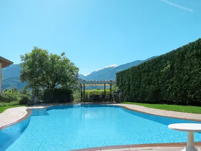 a swimming pool in a yard with a hedge at Apartment Boymont by Interhome in Postal