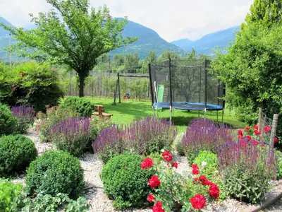 a garden with flowers and a playground at Apartment Boymont by Interhome in Postal