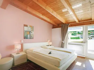 a bedroom with a large bed and a window at Apartment Bellavista by Interhome in Postal