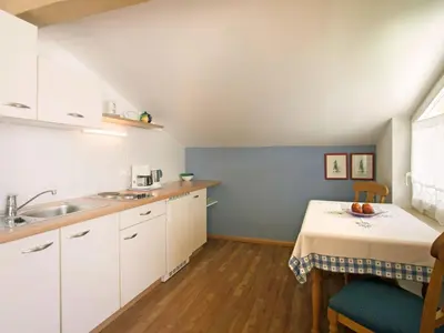 a kitchen with white cabinets and a table at Apartment Bellavista by Interhome in Postal