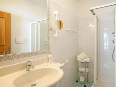 a white bathroom with a sink and a shower at Apartment Bellavista by Interhome in Postal