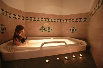 a woman is sitting in a bath tub at Appartamenti Arnica in Alba di Canazei