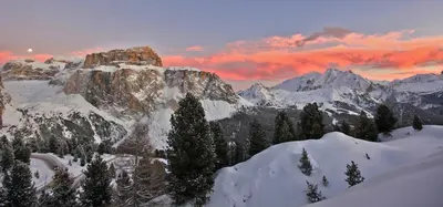 a mountain covered in snow with a sunset in the background at Appartamenti Arnica in Alba di Canazei