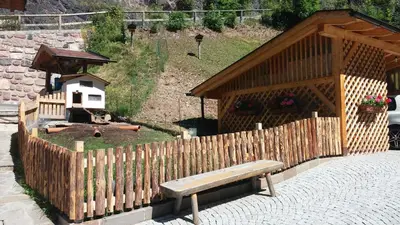 a wooden bench sitting in front of a wooden fence at B&B El Molin in Cavalese