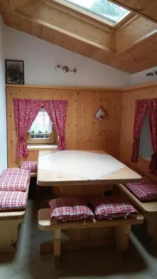 a room with a large bed and two benches at B&B El Molin in Cavalese