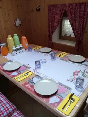a table with white plates and utensils on it at B&B El Molin in Cavalese