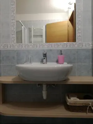 a bathroom with a white sink and a mirror at B&B El Molin in Cavalese