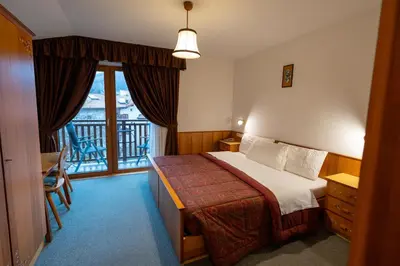 a hotel room with a bed and a balcony at Albergo Pensione Serenetta in Varena