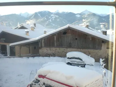 a snow covered car parked in front of a house at Albergo Pensione Serenetta in Varena