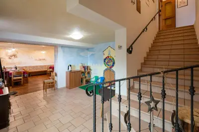 a room with a staircase and a living room at Albergo Pensione Serenetta in Varena