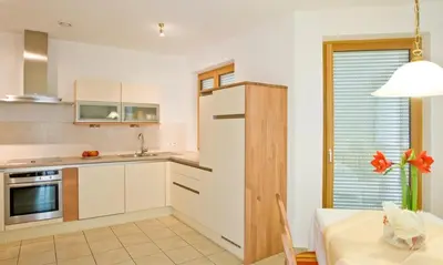 a kitchen with white cabinets and a table and a window at Chalet Anna in Marlengo