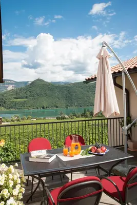 a patio with a table and chairs and an umbrella at Weingut Morandell in Caldaro
