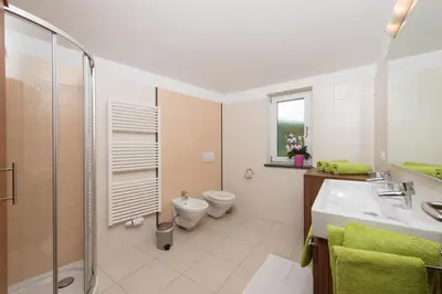 a bathroom with a sink and a toilet and a shower at Weingut Morandell in Caldaro