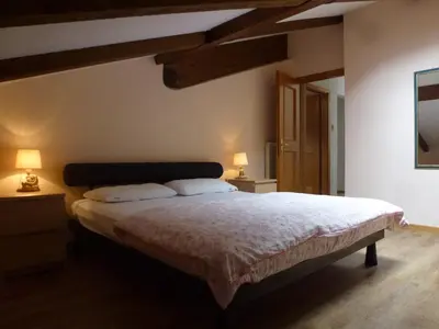 a bedroom with a large bed with two lamps at Casa Angela in Predazzo