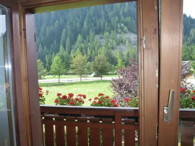 a window with a view of a field of flowers at Casa Angela in Predazzo