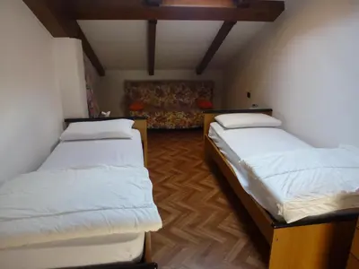 a room with two beds and a couch at Casa Angela in Predazzo